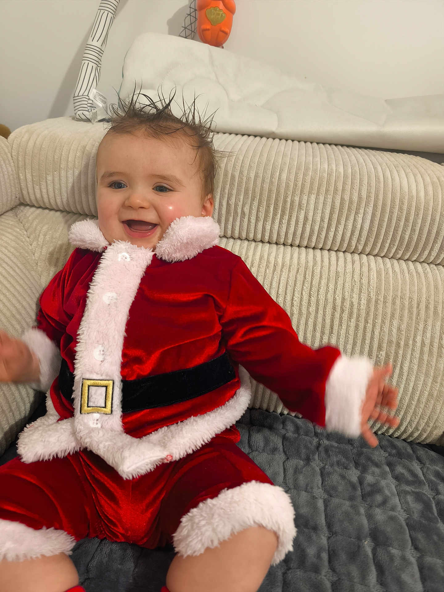 Eden participe au concours pour gagner de l'argent avec cette photo : baby, child, smiling, red_clothing, santa_costume, white_fur_trim, couch, indoor, happy, infant, person, holiday, festive, plush, furniture, portrait, cute, cozy, cheerful, seated
