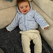 Eden a rejoint le concours — aidez-le/la à gagner de superbes lots ! baby, blanket, child, clothing, couch, cozy, footwear, hair, happy, indoor, infant, jacket, pants, person, relaxed, seated, smiling, sneakers, soft, texture