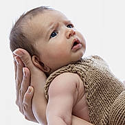 Samuil is registered to the contest to win money with this photo: baby, infant, hands, knitted_clothing, brown_outfit, portrait, closeup, skin, expression, curious, adult_hands, supporting, soft_light, studio, newborn, child, human, cute, face, baby_girl