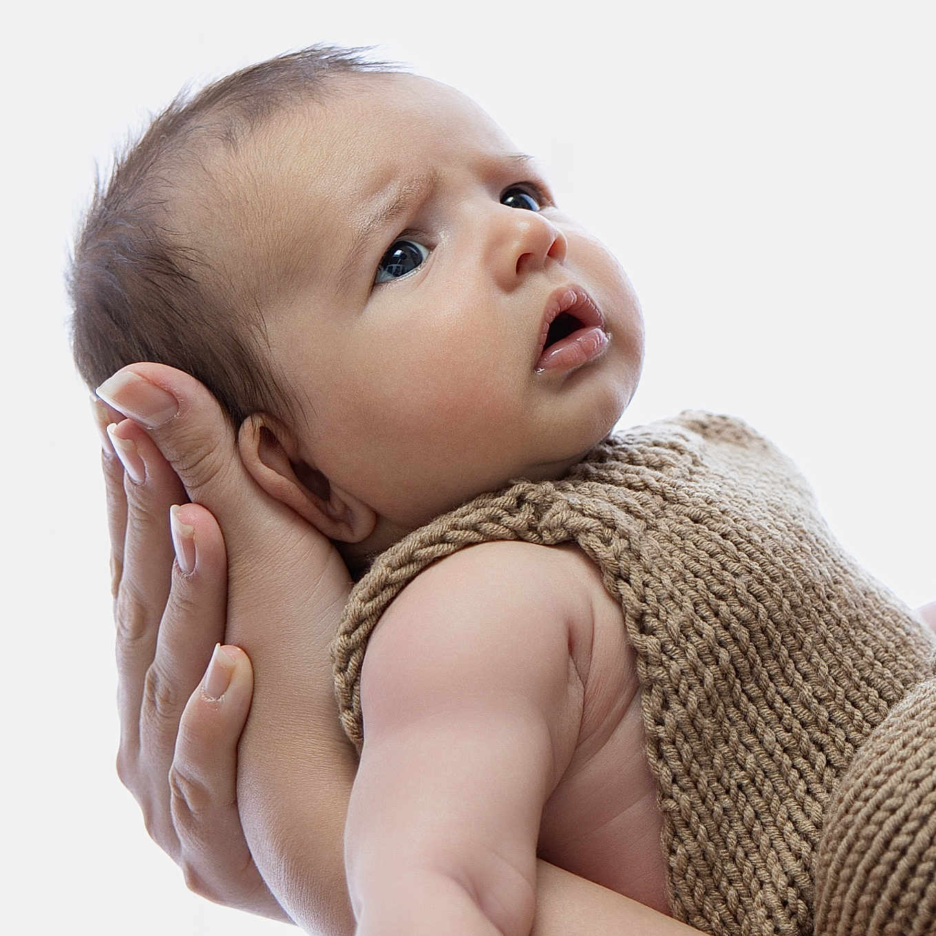 Samuil is registered to the contest to win money with this photo: baby, infant, hands, knitted_clothing, brown_outfit, portrait, closeup, skin, expression, curious, adult_hands, supporting, soft_light, studio, newborn, child, human, cute, face, baby_girl