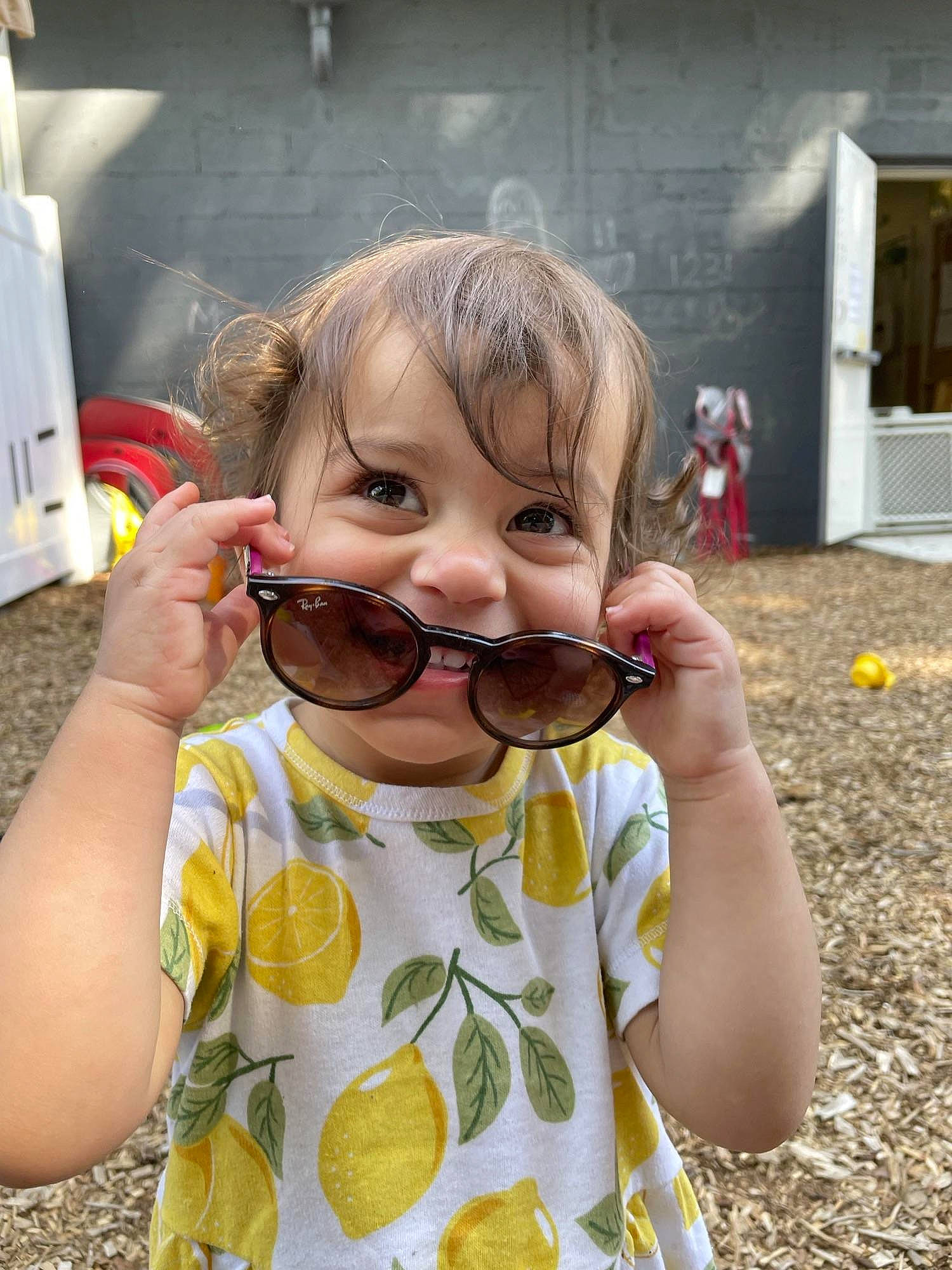Ariella is registered to the contest to win money with this photo: bangs, beard, child, cool, door, drinking, eyelash, eyewear, finger, fun, glasses, goggles, happy, paper_towel, person, personal_protective_equipment, sleeve, sunglasses, t_shirt, toddler