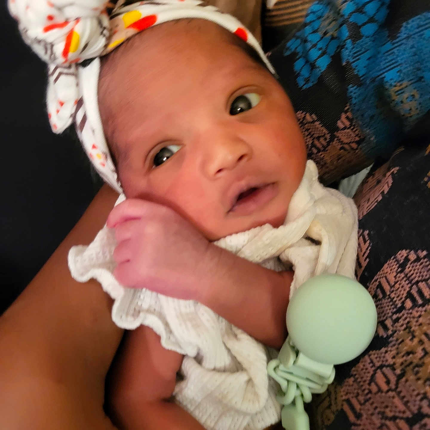 Chadni Maya joined the competition — help win amazing prizes! adult, baby, closeup, cloth, cradled, cute, expression, eyes, face, hand, headband, holding, indoor, infant, newborn, newborn_baby, patterned_clothing, person, skin, soft