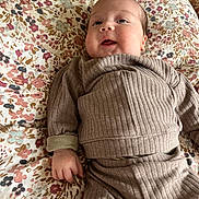 Marcel a rejoint le concours — aidez-le/la à gagner de superbes lots ! baby, infant, child, smiling, face, hand, clothing, bedspread, floral_pattern, fabric, lying_down, cute, young_child, indoors, portrait, person, soft_light, comfort, cozy, expression