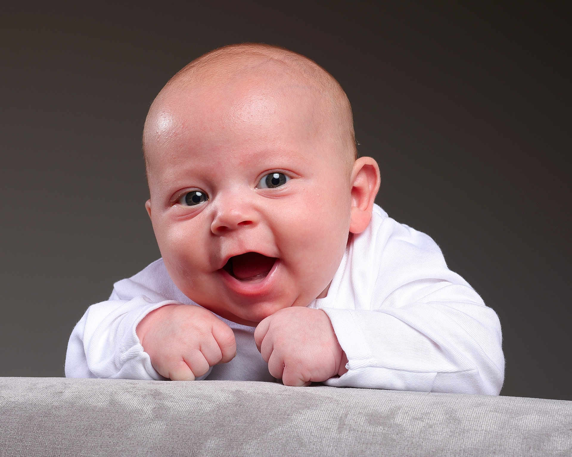 Freddie joined the competition — help win amazing prizes! baby, infant, smile, happy, face, hands, white_clothing, portrait, cute, child, skin, head, expression, toddler, closeup, background, studio, young, joy, human