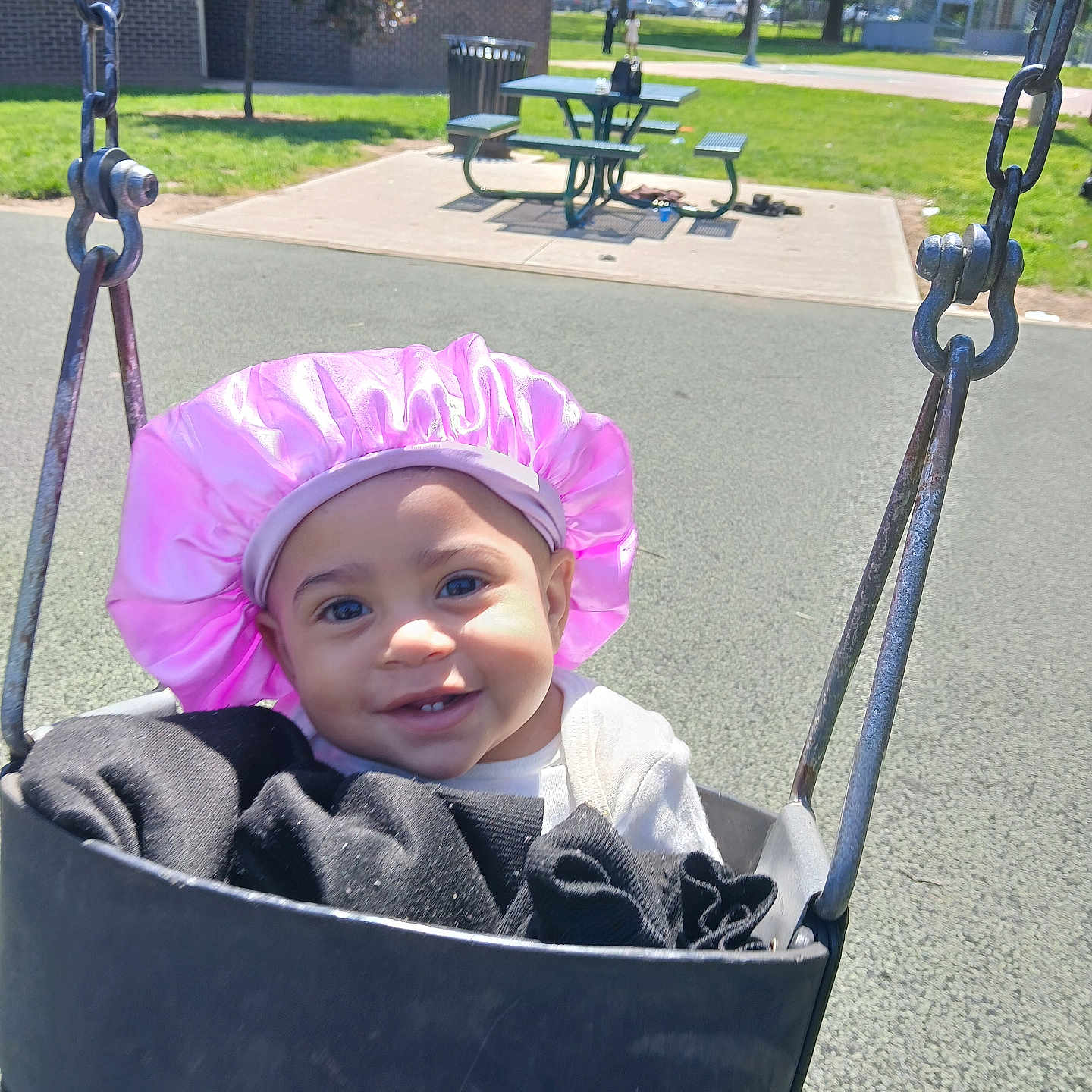 Lanyiah joined the competition — help win amazing prizes! baby, basketball_hoop, bench, black_swing, child, clothing, daylight, grass, happy, infant, outdoor, park, picnic_table, pink_bonnet, play, playground, smiling, sunny, swing, tree