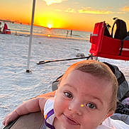 Saphira is registered to the contest to win money with this photo: baby, beach, clothing, coast, face, head, lifejacket, nature, outdoors, person, photography, portrait, sea, shoreline, sky, summer, sun, vest, water, waterfront