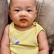 Ryan joined the competition — help win amazing prizes! baby, child, infant, yellow_clothing, couch, beige_couch, face, food_on_face, sitting, indoors, curious_expression, plush_couch, arms, head, person, young_child, portrait, cute, skin, eyes