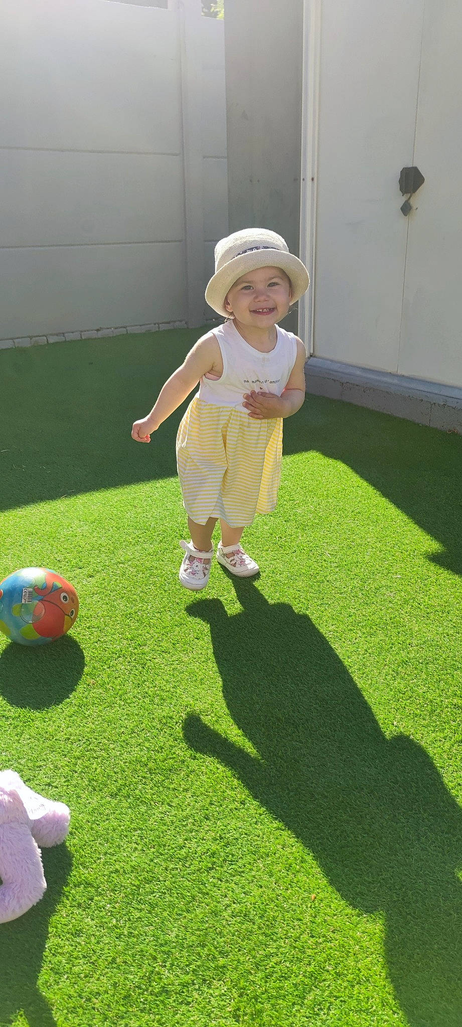 Ilyana participe au concours pour gagner de l'argent avec cette photo : baby, baby_toddler_clothing, ball, child, flooring, football, fun, grass, hat, headwear, joy, lawn, leisure, people_in_nature, person, player, recreation, smile, soccer_ball, sports_equipment