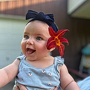 Elly joined the competition — help win amazing prizes! baby, background_blur, blue_clothing, child, cute, eyes, flower, hand, happy, head, headband, holding, infant, mouth, nature, outdoor, person, portrait, skin, smiling