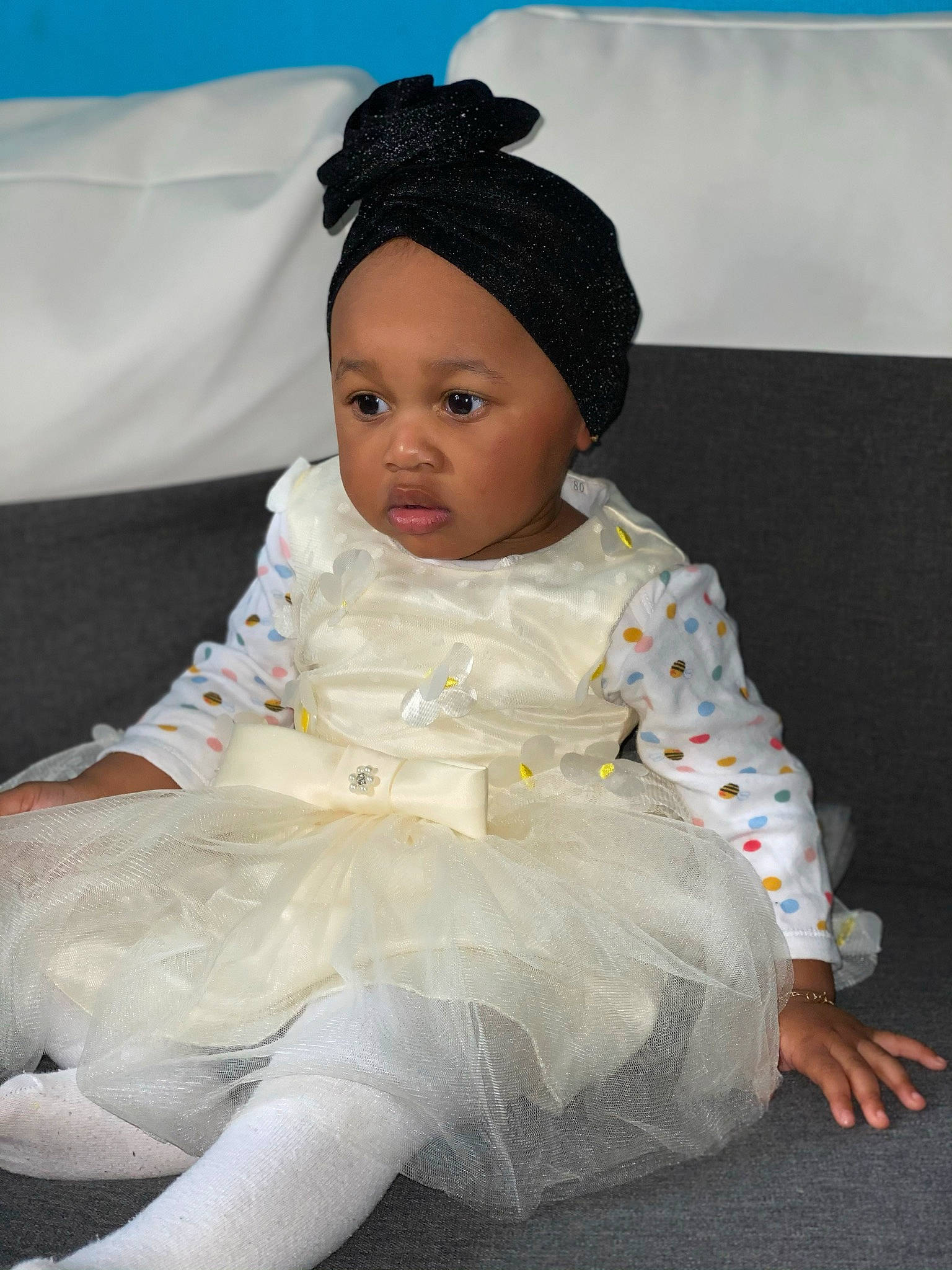 Lyna participe au concours pour gagner de l'argent avec cette photo : baby, baby_products, baby_toddler_clothing, child, clothing, costume, dress, hair_accessory, head, headgear, headwear, person, sitting, skin, sleeve, toddler, white