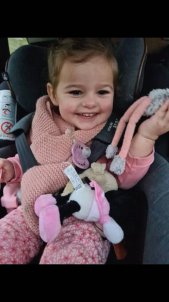 Anna participe au concours pour gagner de l'argent avec cette photo : baby, baby_toddler_clothing, car_seat, cheek, child, comfort, finger, gesture, hand, happy, joy, lip, motor_vehicle, person, pink, seat_belt, skin, smile, steering_wheel, thumb