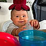 Capucine a rejoint le concours — aidez-le/la à gagner de superbes lots ! baby, child, high_chair, bottle, toy, plush_octopus, smiling, happy, indoor, face, hand, clothing, table, cup, furniture, plant, blue, red, headwear, portrait
