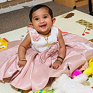 Deona joined the competition — help win amazing prizes! baby, child, dress, pink_dress, smile, happy, play_mat, plush_toy, stuffed_animal, yellow_duck, sitting, bracelet, necklace, indoor, carpet, floor, cute, portrait, young_child, person