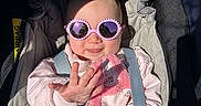Margaux participe au concours pour gagner de l'argent avec cette photo : airbag_label, baby, car_seat, child, closeup, clothing, cute, harness, infant, onesie, pink_bib, pink_sunglasses, portrait, safety_strap, shadow, smile, stroller, sunglasses, sunlight, tongue_out