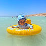 Jaouen participe au concours pour gagner de l'argent avec cette photo : beach, child, floating, fun, hat, inflatable_ring, nature, outdoor, playful, sea, sky, smile, summer, sun_hat, sunny, swimwear, toddler, vacation, water, yellow
