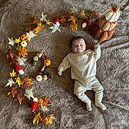 Lenzo a rejoint le concours — aidez-le/la à gagner de superbes lots ! autumn, baby, blanket, brown, child, cozy_clothing, cream, cute, decor, fall, indoors, infant, leaves, lying_down, mushrooms, pinecones, pumpkins, seasonal, smiling, soft_texture