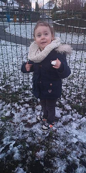 Maëllya a rejoint le concours — aidez-le/la à gagner de superbes lots ! baby, baby_toddler_clothing, child, face, fence, freezing, fun, grass, happy, head, mesh, pattern, people_in_nature, person, sleeve, smile, snow, toddler, tree, winter