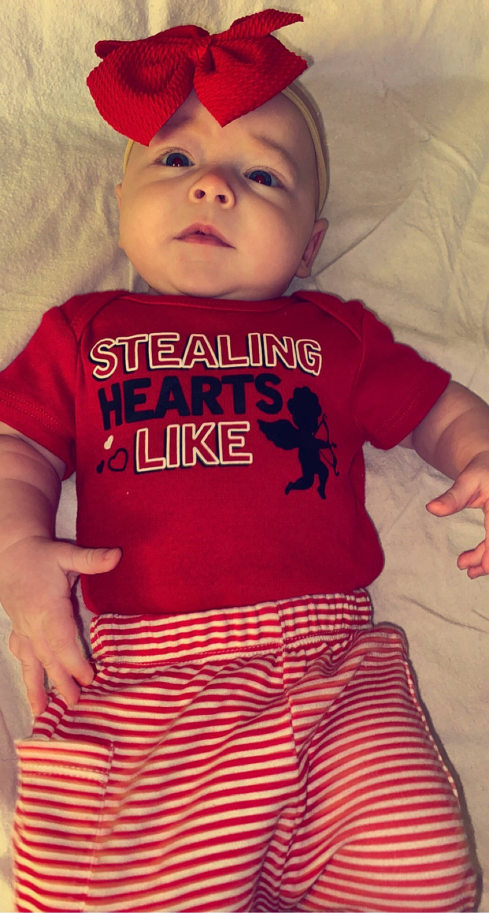 April is registered to the contest to win money with this photo: baby, baby_toddler_clothing, black, cap, cool, eye, face, facial_expression, happy, head, headwear, jersey, lip, organ, outerwear, person, pink, product, sleeve, t_shirt