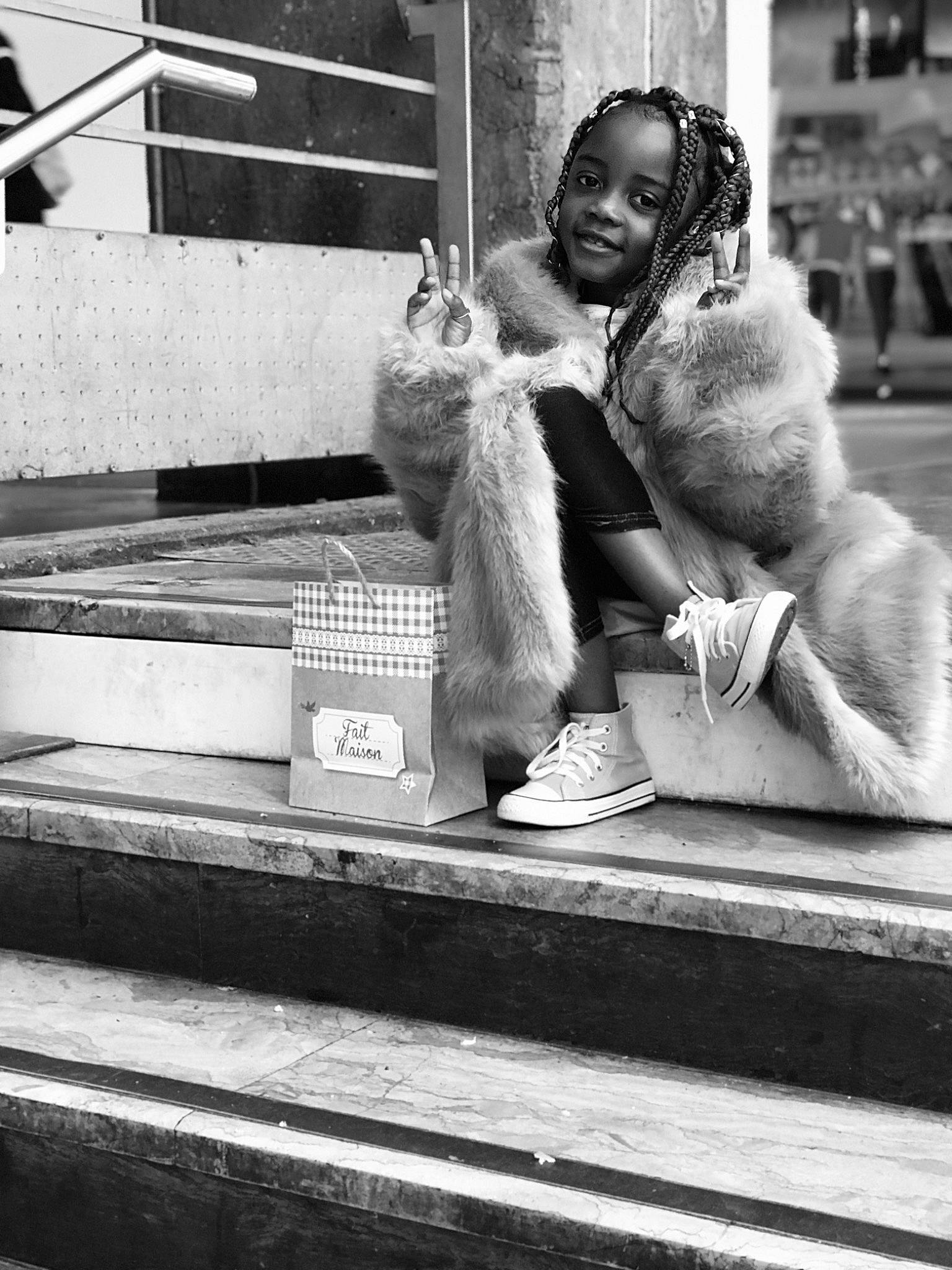 Sybelle-margot participe au concours pour gagner de l'argent avec cette photo : black, black_and_white, child, dress, fur, gesture, grey, happy, human_leg, joy, monochrome, monochrome_photography, person, photograph, road, sitting, smile, snapshot, street, street_fashion