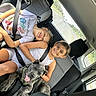 child, children, dog, car, seatbelt, car_seat, smile, happy, pet, animal, backseat, window, road, travel, friendship, casual_clothing, summer, daytime, interior, family