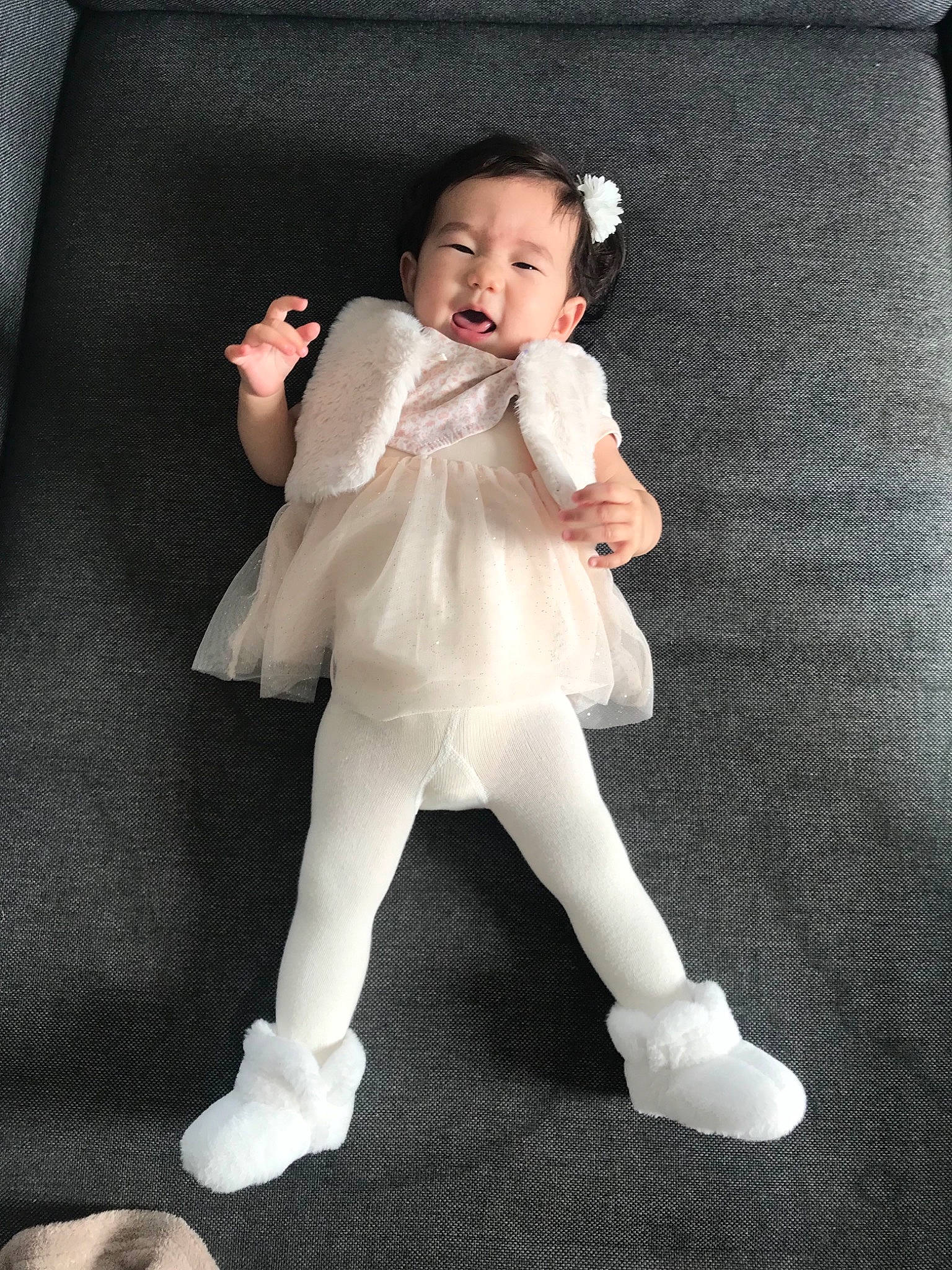 Charlotte participe au concours pour gagner de l'argent avec cette photo : baby, baby_toddler_clothing, child, comfort, day_dress, face, flash_photography, foot, fun, fur, gesture, head, human_leg, knee, person, sitting, sleeve, sock, thigh, thumb