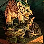 cat, tabby_cat, stone_statue, tiger_statue, pedestal, licking, animal, feline, sculpture, shadow, lighting, outdoor, night, stone, texture, wildlife, companion, predator, playful, closeup