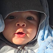 Joud Hajjo joined the competition — help win amazing prizes! baby, child, hood, jacket, zipper, blanket, blue_blanket, face, eyes, mouth, curious, closeup, infant, soft_texture, clothing, cute, portrait, warm, indoors, person