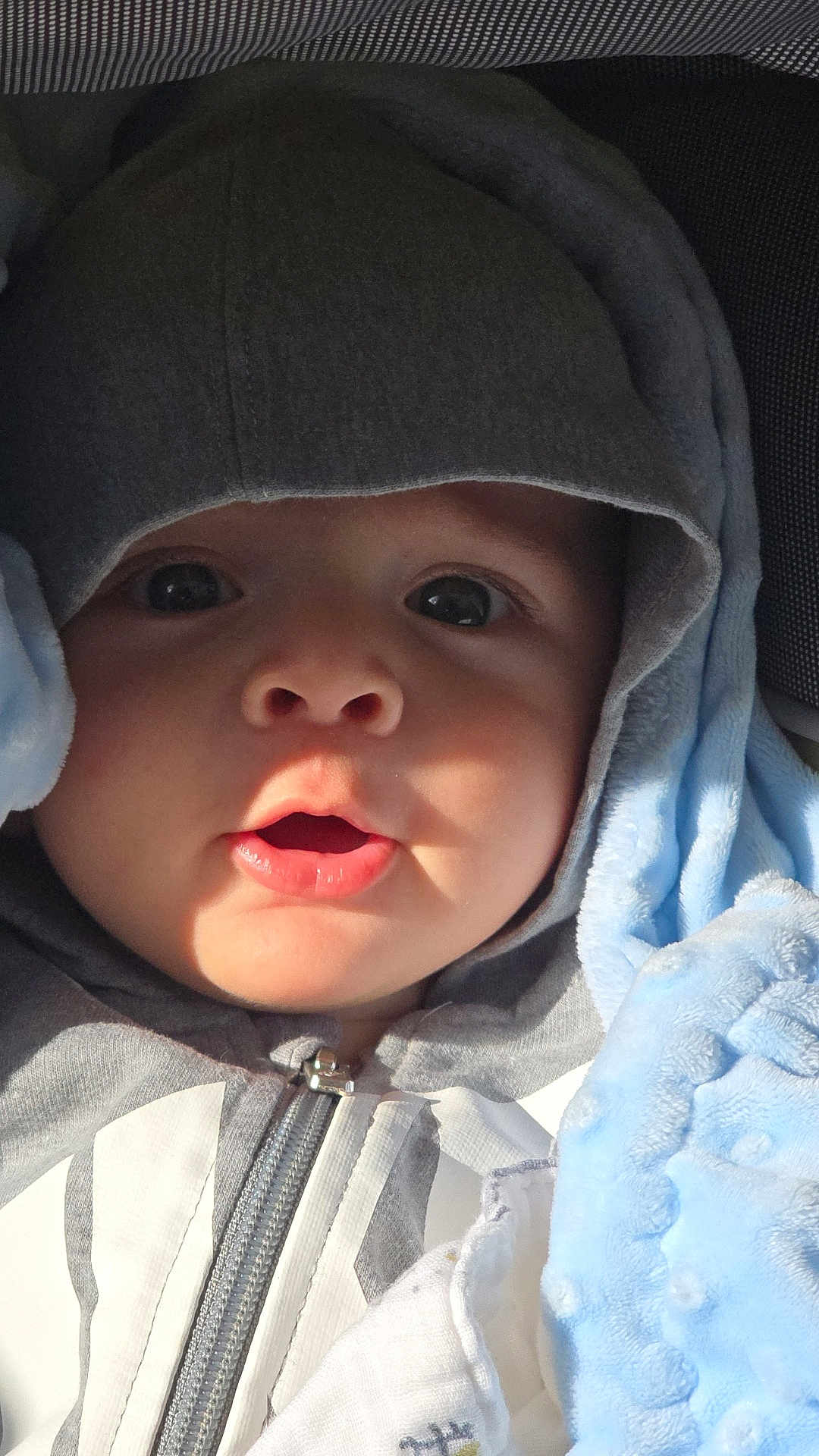 Joud Hajjo joined the competition — help win amazing prizes! baby, child, hood, jacket, zipper, blanket, blue_blanket, face, eyes, mouth, curious, closeup, infant, soft_texture, clothing, cute, portrait, warm, indoors, person