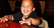 Dexter joined the competition — help win amazing prizes! baby, black_shirt, booth, child, cute, face, furniture, hair, hands, happy, high_chair, indoor, joy, lighting, person, restaurant, seat, smiling, table, toddler