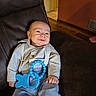 baby, blue_eyes, child, clothing, cute, drool, furniture, happy, indoor, infant, leather_couch, pants, person, portrait, relaxing, shirt, smile, suspenders, teething_toy, young