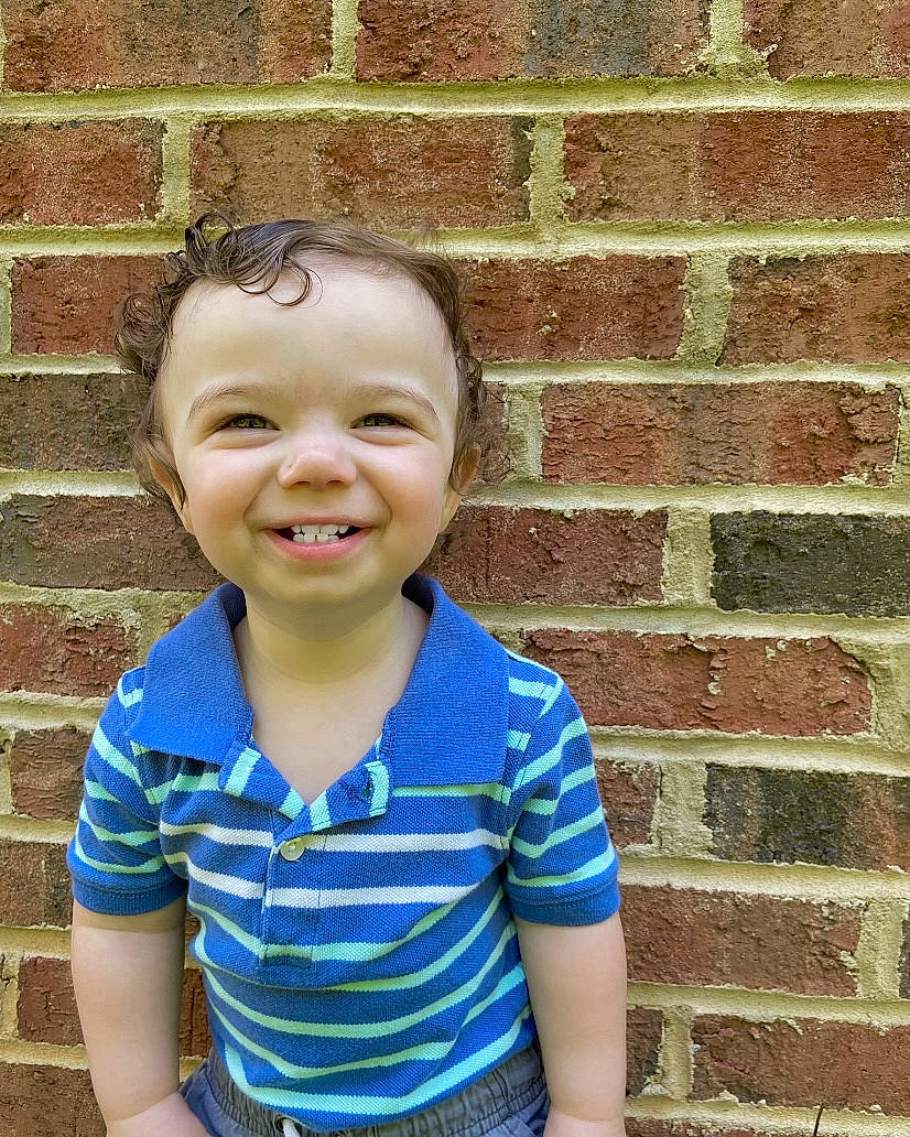 Waylon is registered to the contest to win money with this photo: brick, brickwork, child, electric_blue, eye, facial_expression, flash_photography, forehead, fun, hair, happy, joy, mouth, pattern, people, person, sleeve, smile, standing, t_shirt