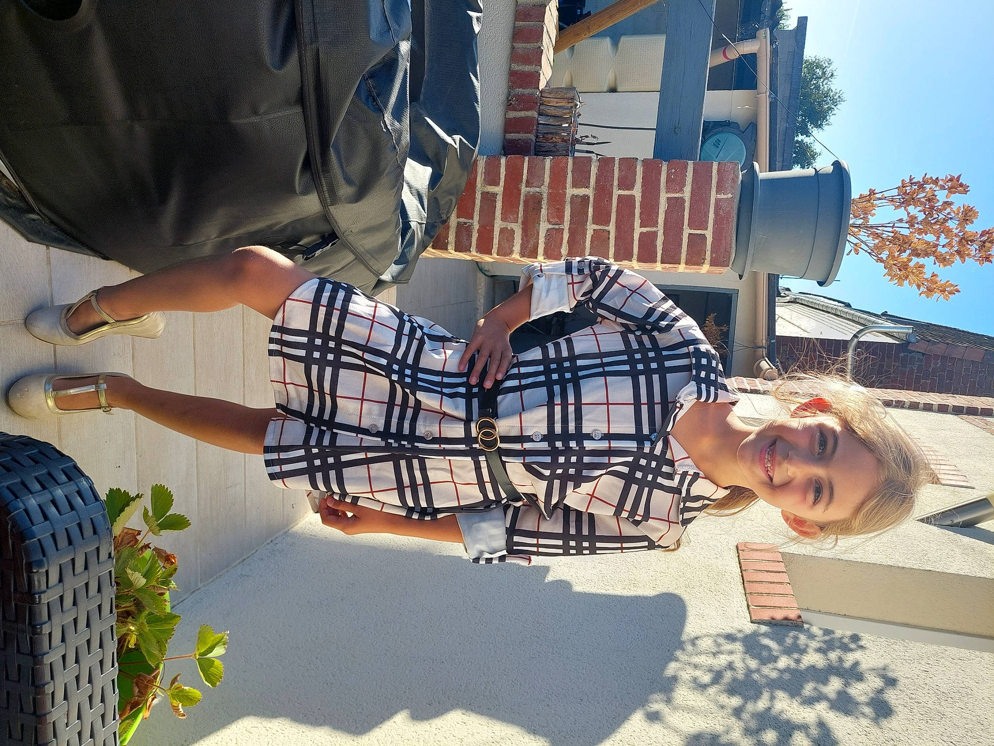 Lola participe au concours pour gagner de l'argent avec cette photo : building, cool, daytime, eyewear, fun, happy, house, human_leg, joy, leisure, organ, person, plaid, plant, sky, summer, tartan, thigh, travel, tree