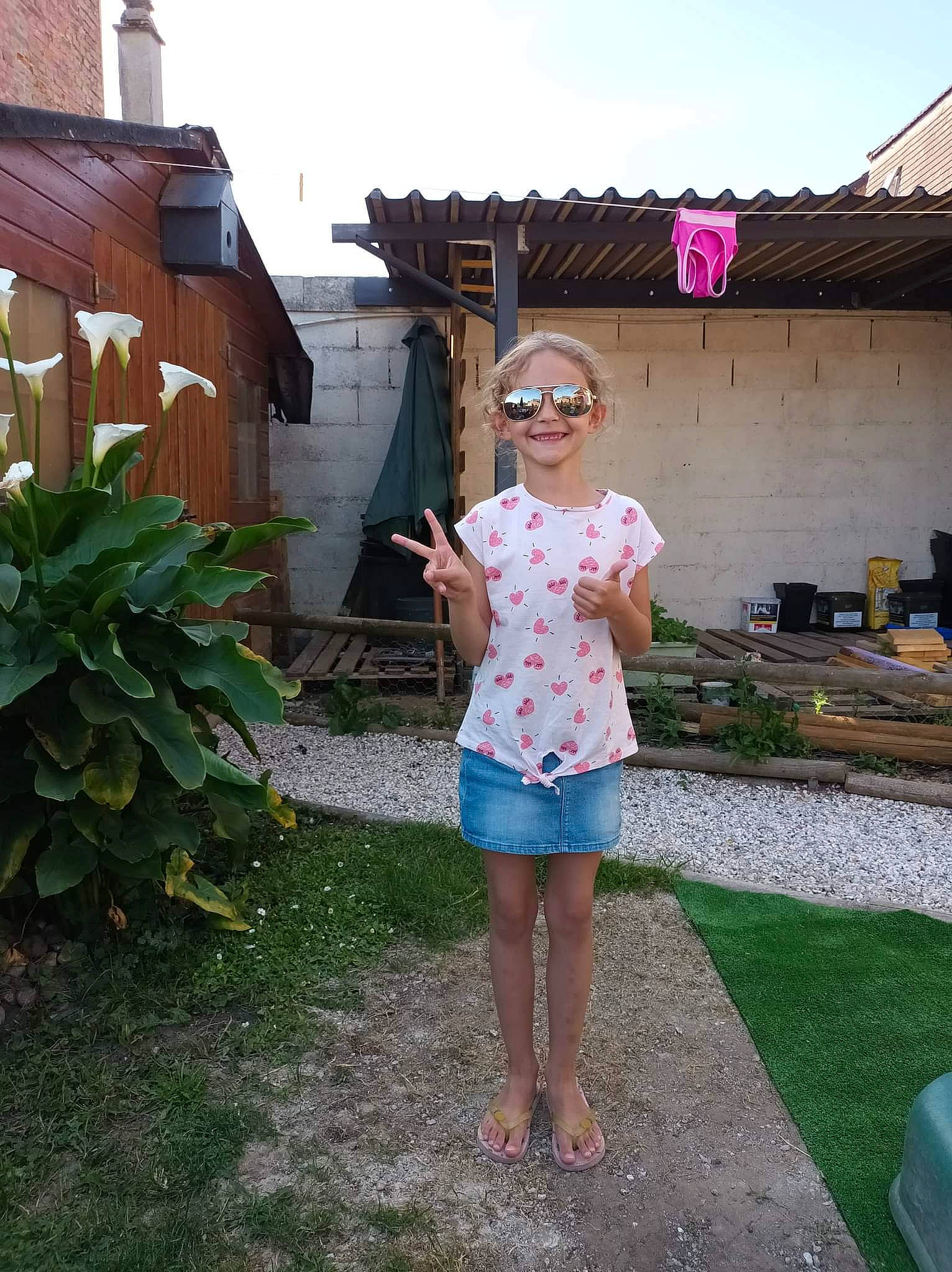Lola participe au concours pour gagner de l'argent avec cette photo : barefoot, denim, eyewear, foot, fun, garden, grass, home, house, joy, leisure, pattern, people, person, plant, public_space, roof, shorts, sky, smile