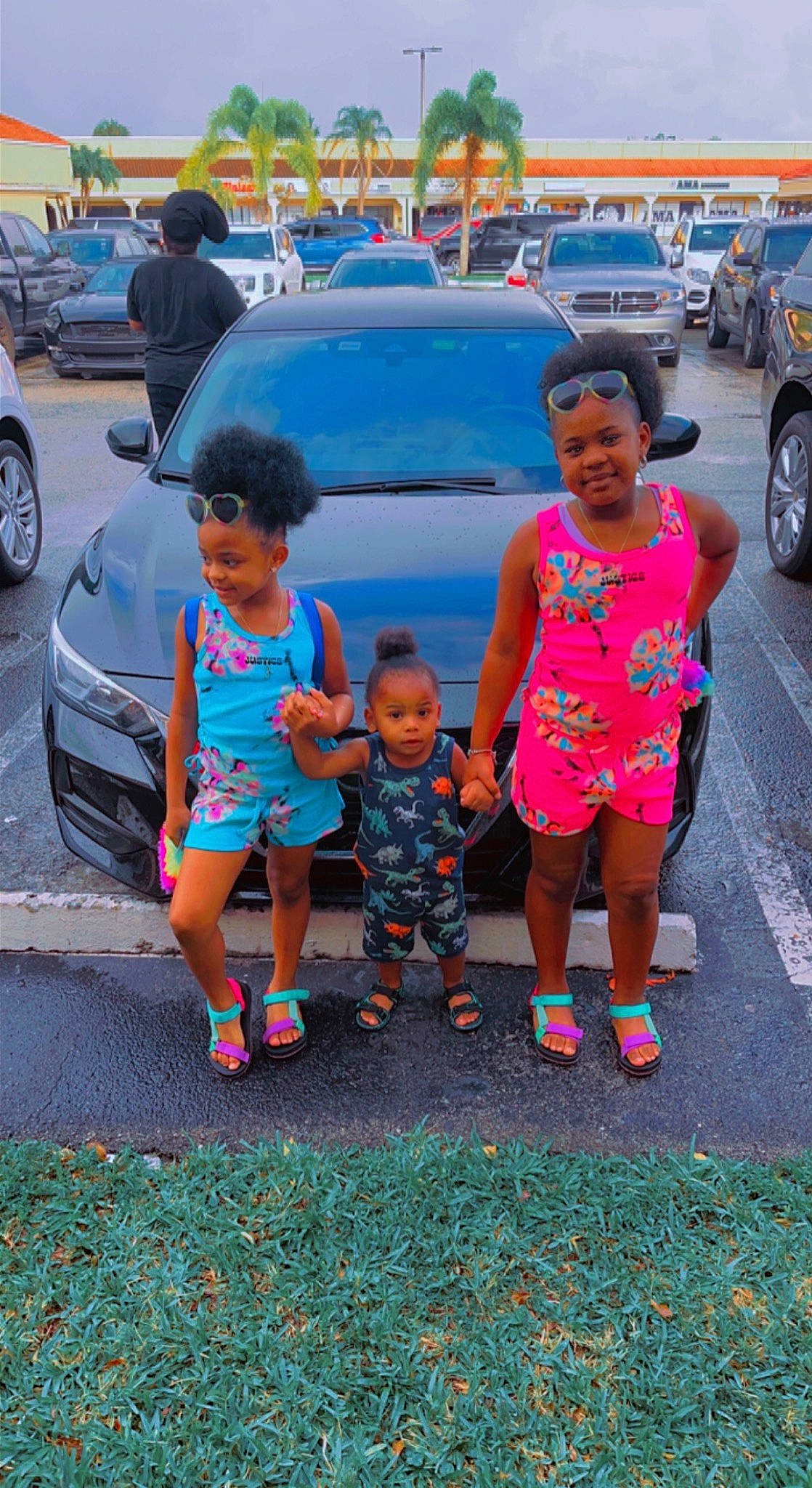 Darius is registered to the contest to win money with this photo: asphalt, automotive_exterior, automotive_lighting, car, child, fun, headwear, joy, land_vehicle, motor_vehicle, person, pink, sandal, shoe, shorts, sidewalk, summer, t_shirt, tire, toddler