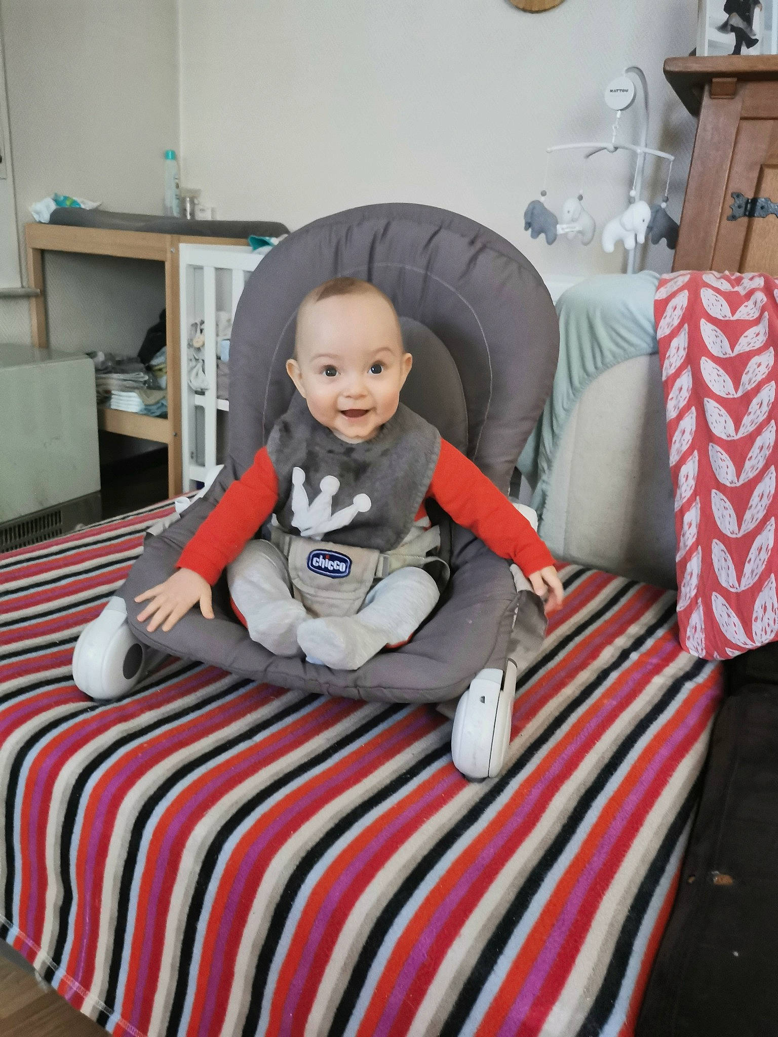 Louis participe au concours pour gagner de l'argent avec cette photo : baby, baby_toddler_clothing, chair, child, comfort, couch, floor, flooring, furniture, knee, lamp, lap, living_room, person, pillow, room, sitting, smile, t_shirt, table