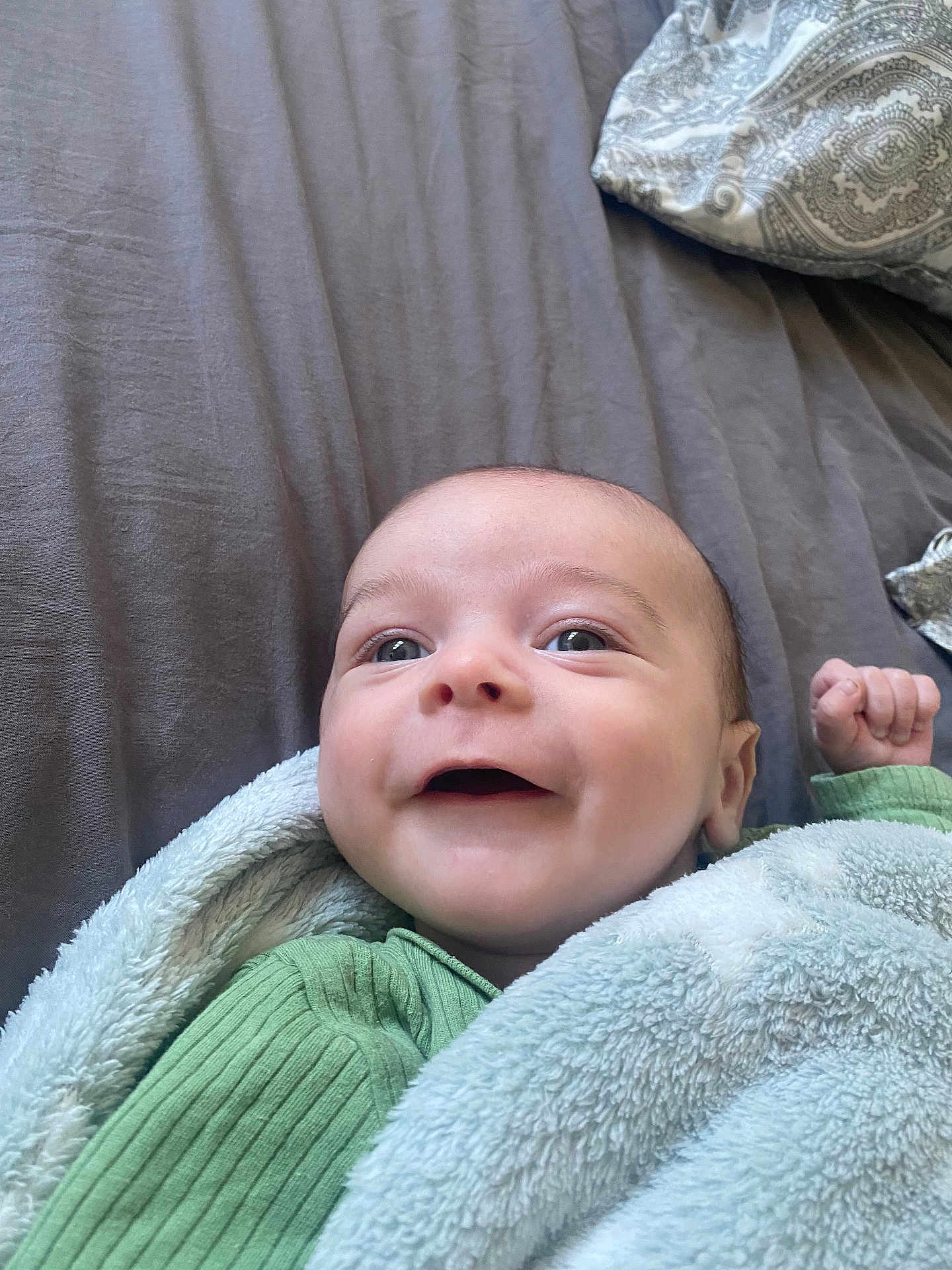 Malo a rejoint le concours — aidez-le/la à gagner de superbes lots ! baby, infant, smile, blanket, green_clothing, bed, pillow, face, happy, cute, child, person, skin, lying_down, cozy, soft_texture, indoor, portrait, newborn, expression