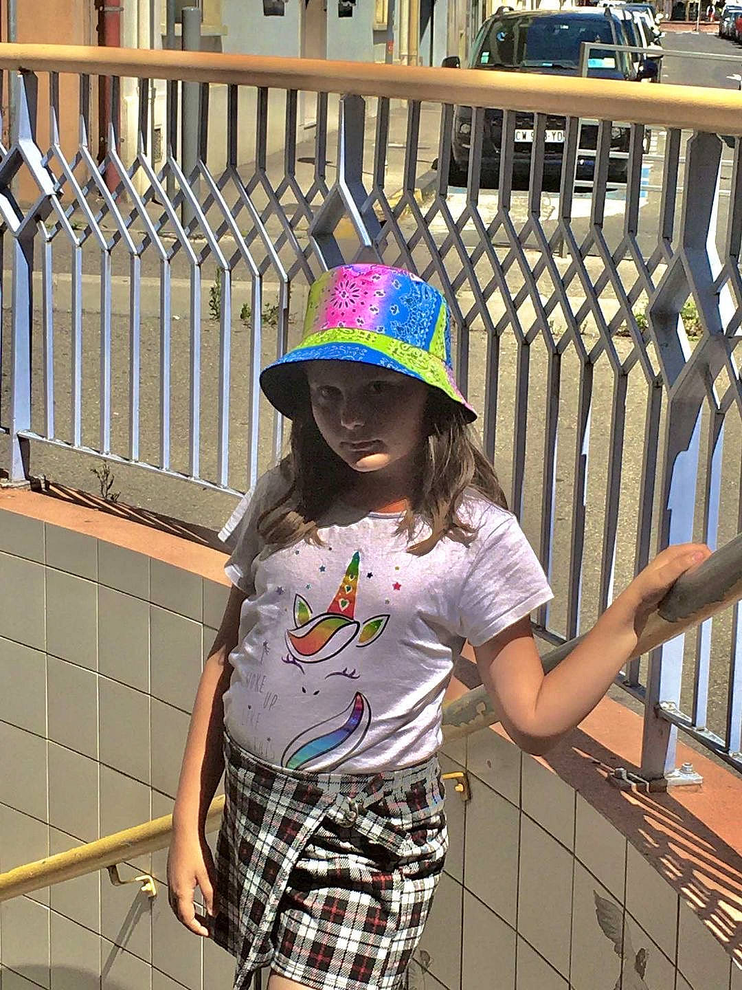 Géraldine participe au concours pour gagner de l'argent avec cette photo : cap, clothing, cool, eyewear, fashion, fence, fun, hairstyle, hat, headwear, human_body, leisure, line, person, photograph, product, sleeve, standing, tartan, thigh