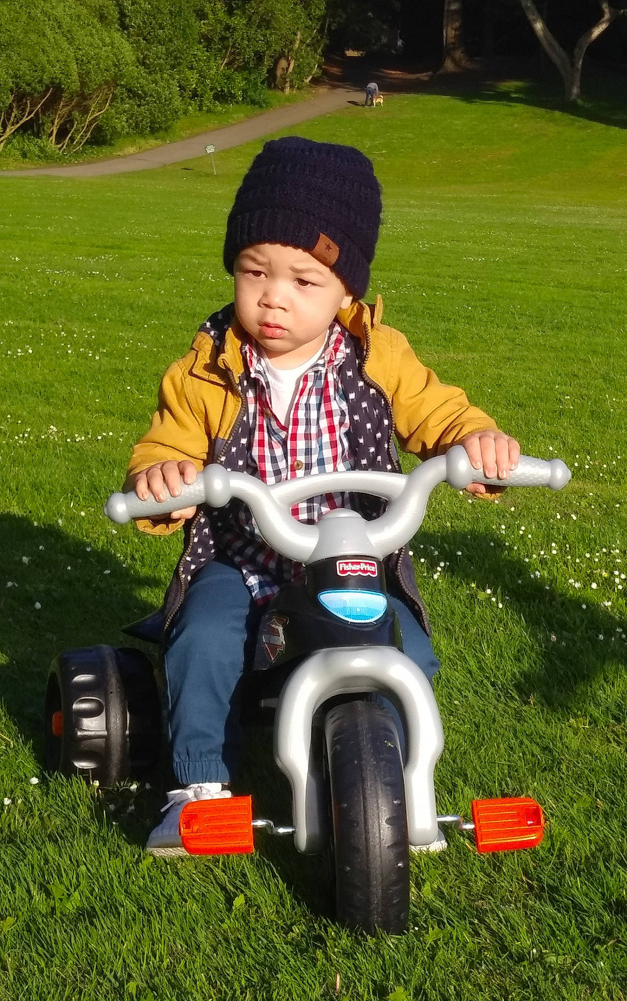 Kalani is registered to the contest to win money with this photo: child, grass, headwear, lawn, person, play, riding_toy, toddler, tricycle, vehicle