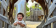 Parvin is registered to the contest to win money with this photo: child, toddler, birthday, balloon, number_one, wooden_playground, outdoor, smile, hat, overalls, shoes, playground_equipment, celebration, happy, daylight, wood, natural_light, person, nature, fun