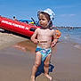 Mathys a rejoint le concours — aidez-le/la à gagner de superbes lots ! barefoot, beach, blue_sky, child, hat, outdoor, people, reflection, rescue_boat, sand, shoreline, stick, summer, sun_hat, sunny, swim_diaper, toddler, umbrella, vacation, water