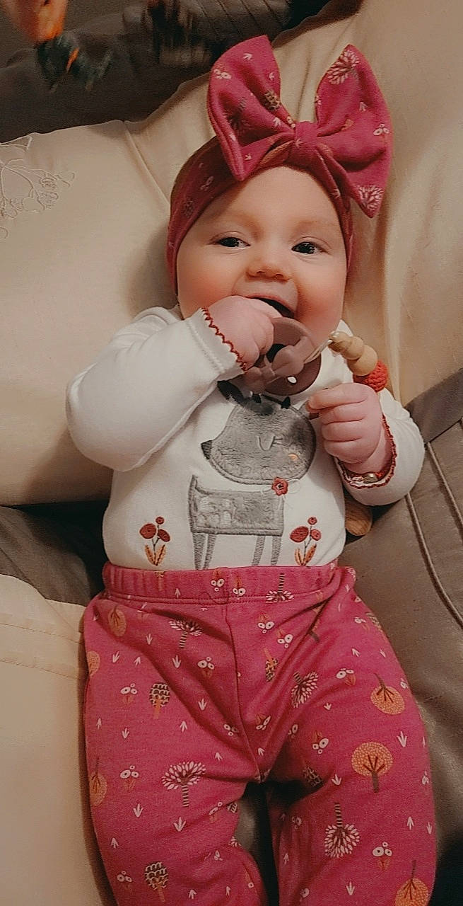Ava Genevieve joined the competition — help win amazing prizes! baby, baby_toddler_clothing, cheek, dress, eye, face, gesture, hand, happy, head, headwear, human_body, lip, nose, outerwear, person, pink, skin, sleeve, smile