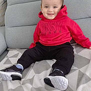 Ilyes a rejoint le concours — aidez-le/la à gagner de superbes lots ! boy, child, clothing, coat, couch, cushion, face, footwear, furniture, head, homedecor, jacket, male, pants, person, photography, portrait, shoe, sitting, sneaker