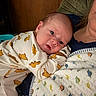 Miles joined the competition — help win amazing prizes! baby, infant, dinosaur_pattern, onesie, blanket, dinosaur_blanket, person, indoor, resting, curious, face, head, child, cuddle, family, closeup, cozy, soft_lighting, portrait, young