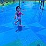 toddler, child, water_park, playground, swimwear, summer, outdoor, water, blue, people, grass, fun, sunny, reflection, shoes, curly_hair, walking, park, family, recreation