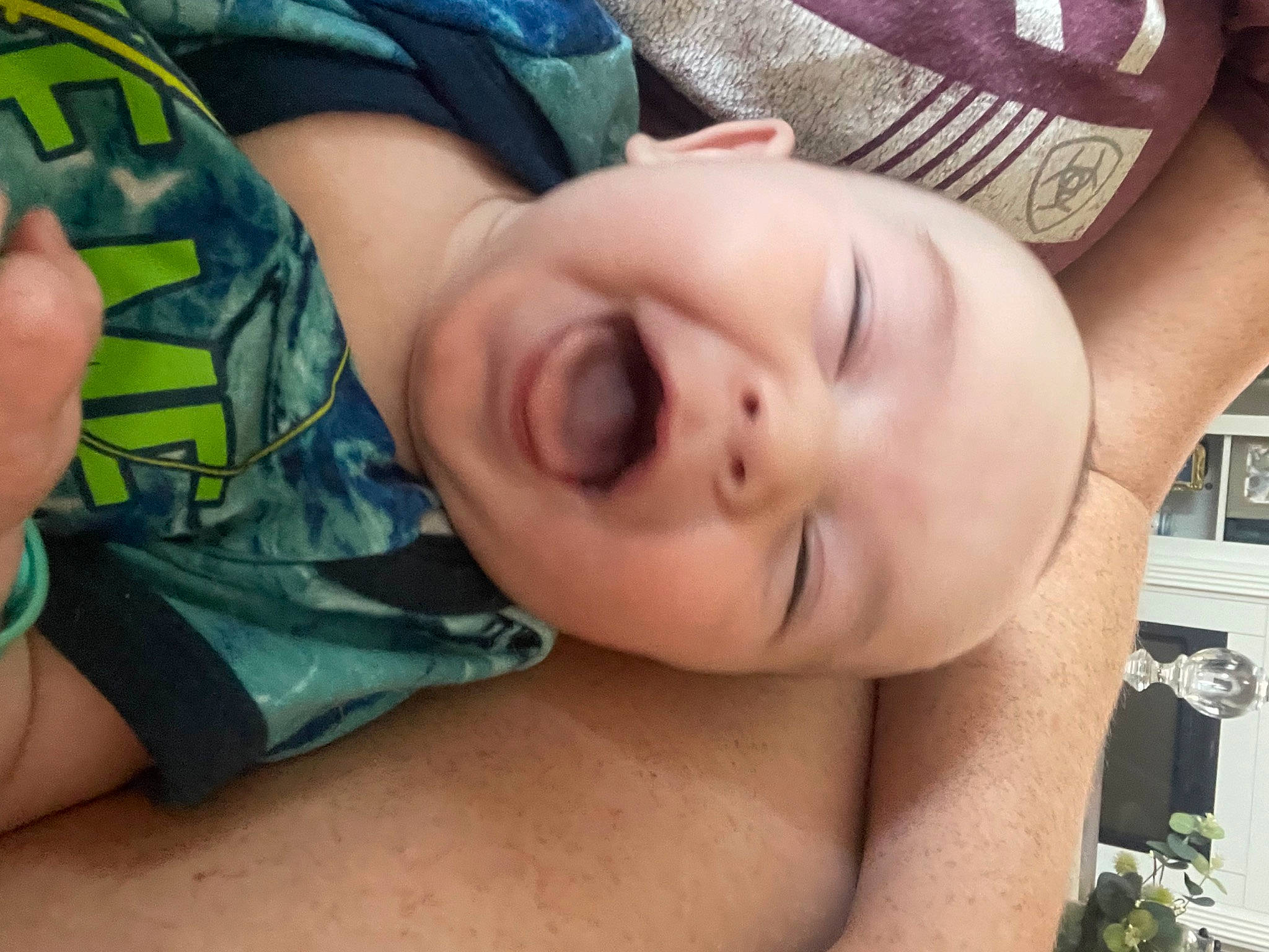 Liam is registered to the contest to win money with this photo: arm, baby, cheek, chin, ear, eye, eyelash, finger, forehead, grass, hand, head, human_body, mouth, muscle, neck, nose, person, plant, skin