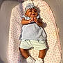 Journee is registered to the contest to win money with this photo: baby, infant, crib, mattress, headband, flower, smile, cute, clothing, shorts, sneakers, white_shoes, socks, mesh, pattern, heart_pattern, laying_down, happy, child, indoor