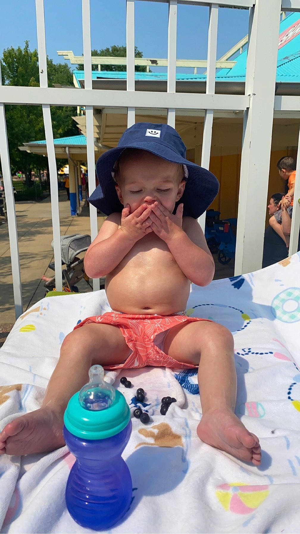 Atticus is registered to the contest to win money with this photo: baseball_cap, blue, cap, child, drinkware, event, fun, hat, human_leg, leisure, people, person, plastic_bottle, recreation, shorts, sky, summer, sun_hat, thigh, toddler