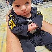 Cayden is registered to the contest to win money with this photo: baby, child, person, infant, clothing, bed, blanket, hand, sitting, face, headwear, indoor, human, skin, arm, cute, young, portrait, holding, fabric