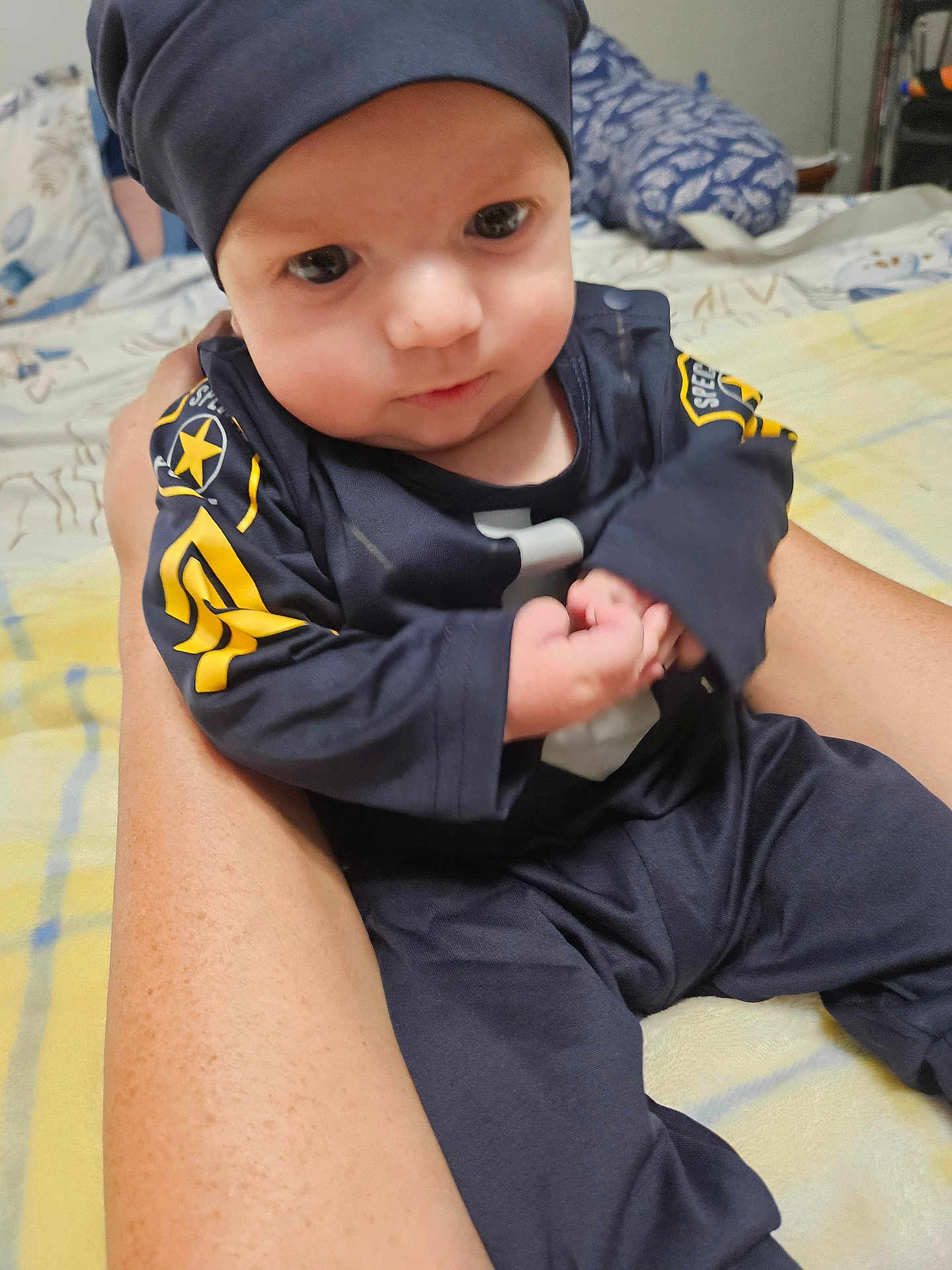 Cayden is registered to the contest to win money with this photo: baby, child, person, infant, clothing, bed, blanket, hand, sitting, face, headwear, indoor, human, skin, arm, cute, young, portrait, holding, fabric