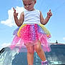 blue_sky, car_hood, casual, child, clouds, colorful, cute, fashion, fun, girl, hair_bows, looking_down, outdoor, pink_sneakers, playful, rainbow, standing, summer, toy_story_twinkle_toes, tutu